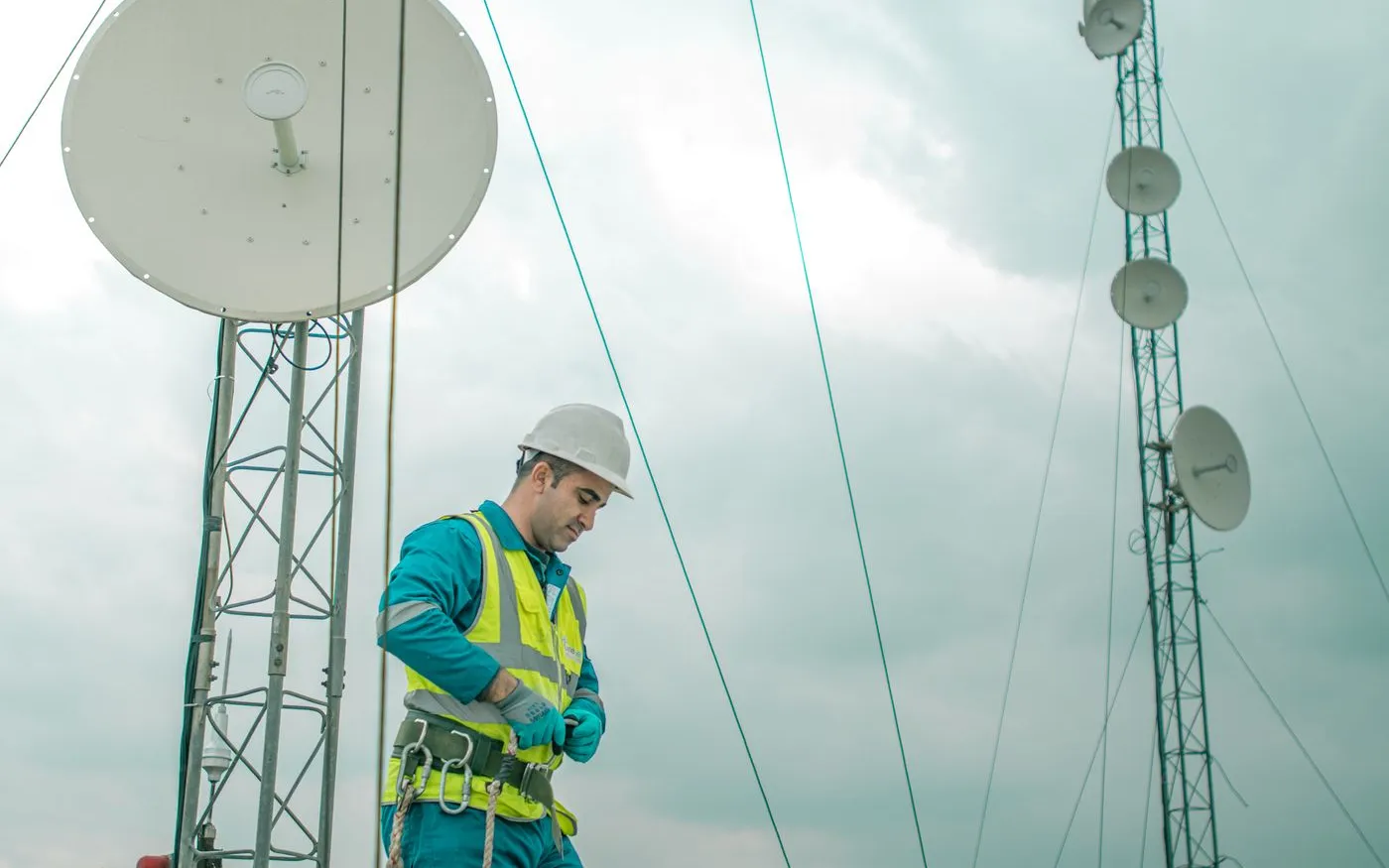 Technician aligning a satellite dish with a signal meter